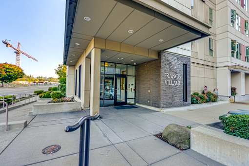 The front of the Francis Village building is shown with a construction crane in the background.
