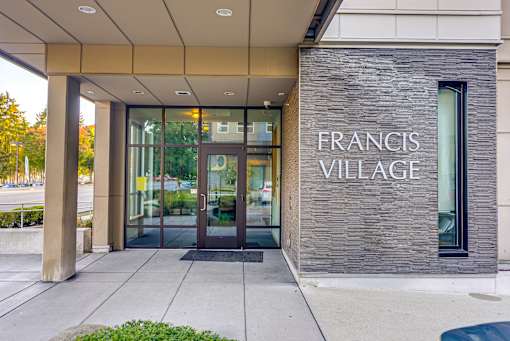 The front of a building with the name "Francis Village" on it.