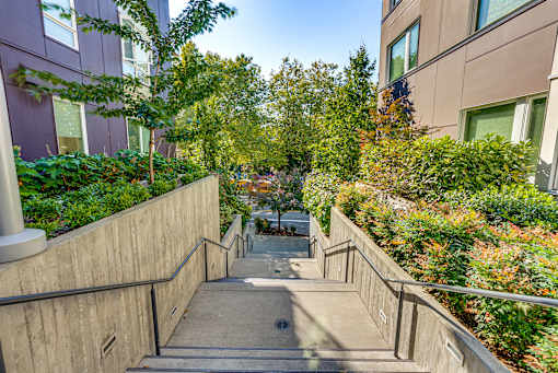 A concrete staircase with metal handrails leads up to a building.