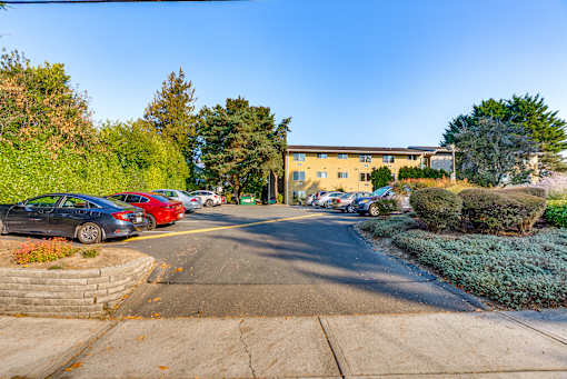 A parking lot with cars and a building in the background.