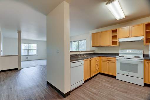 A kitchen with wooden floors and white appliances.