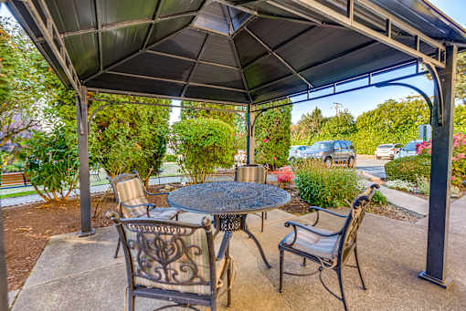A patio with a table and chairs under a roof.