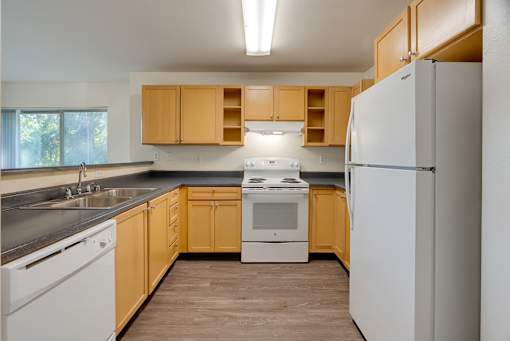 A kitchen with wooden cabinets and white appliances.