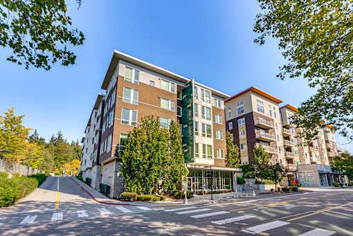 A modern apartment building with a parking lot in front.