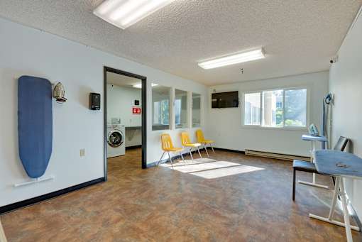 A room with a blue surfboard on the wall and a washing machine in the background.