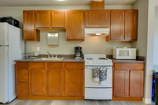 A kitchen with wooden cabinets and a white stove.