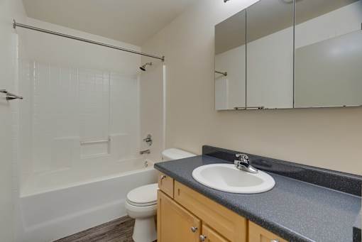 A bathroom with a toilet, sink, and bathtub.