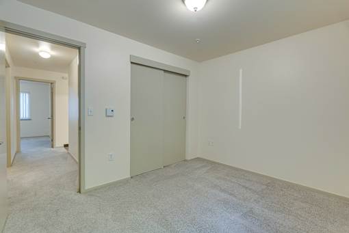 A room with a carpeted floor and a sliding door.