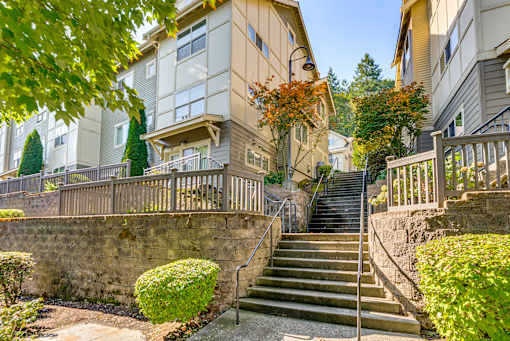 A stone wall with a staircase leading up to a building.