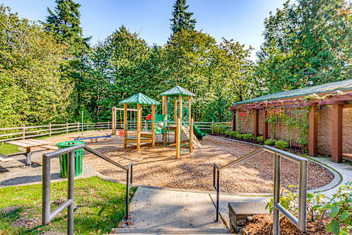 A playground with a green canopy and a slide.