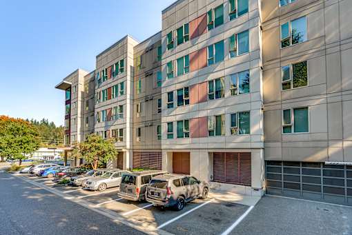 A parking lot in front of a multi-story building.