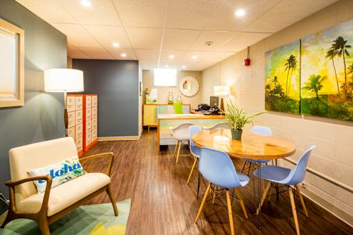 A room with a wooden floor and a painting on the wall.