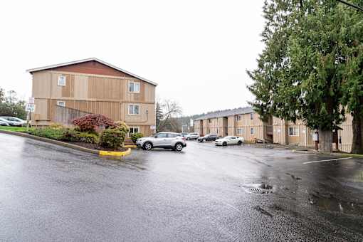 A wet parking lot in front of a building.