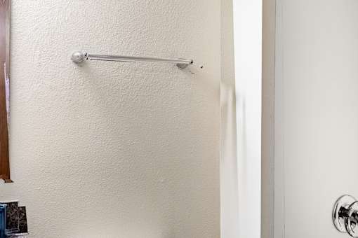 A white door with a silver handle and a silver bar.