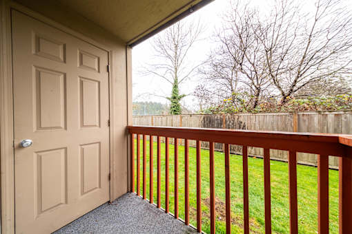 A view from a balcony looking out to a yard.