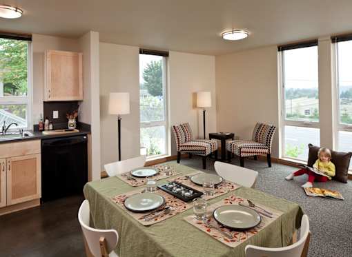 A dining room with a table set for a meal.