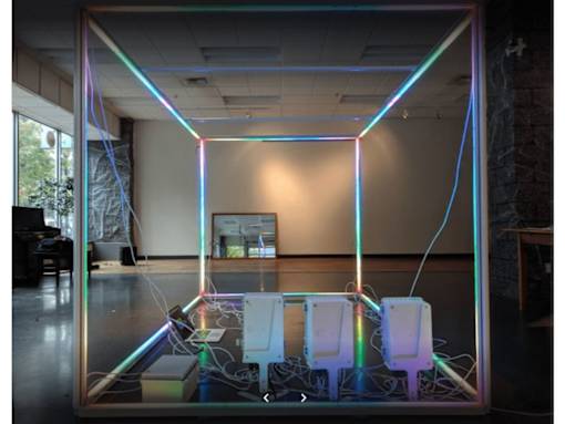 A room with a neon light frame and two white chairs.