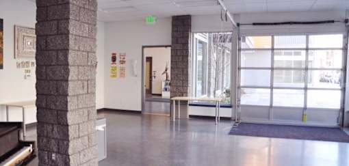 A hallway with a bench and a brick pillar.