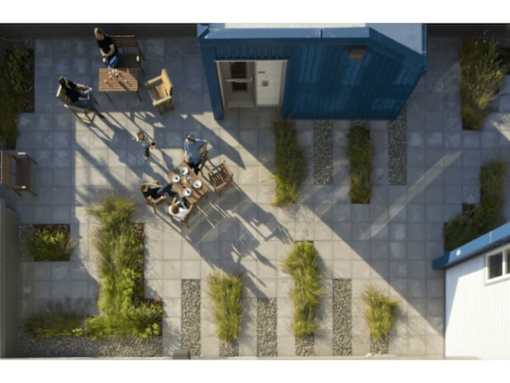 A group of people are gathered around a table outside a building.