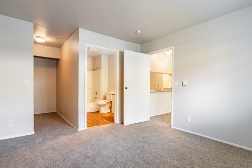 a bedroom with an open door to a bathroom