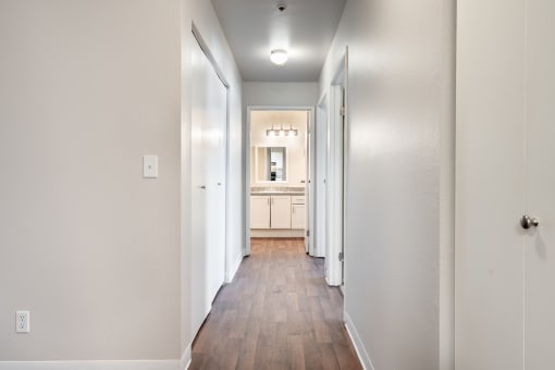 a hallway with wood floors and white walls