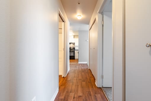 a hallway with wood floors and white walls