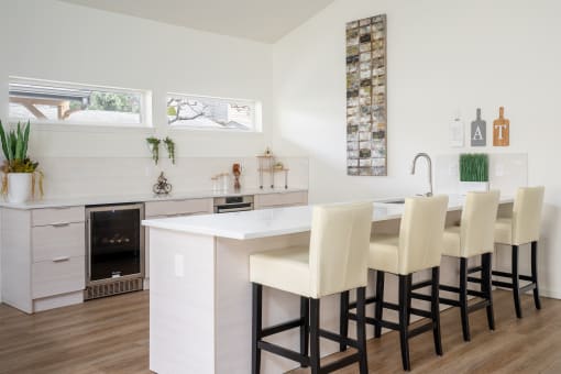 a kitchen with white cabinets and a white island with a white countertop and a row of