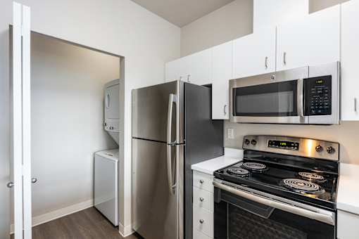 A kitchen with a stove, microwave, and refrigerator.