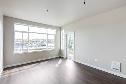 A large empty room with a view of the city through the window.