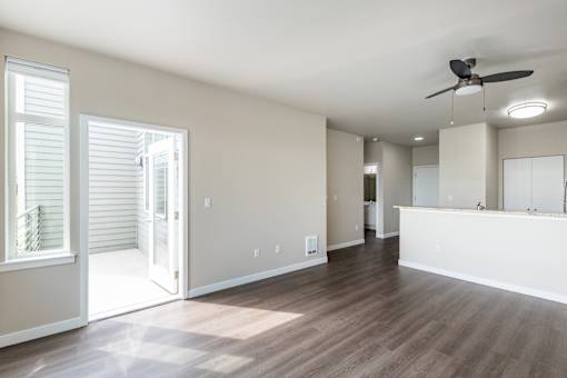 A room with a ceiling fan and wooden flooring.