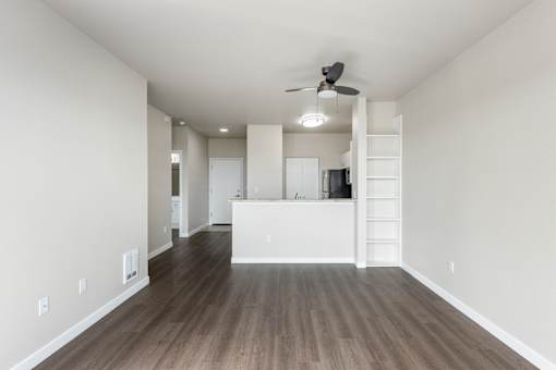 A room with a ceiling fan and wooden flooring.