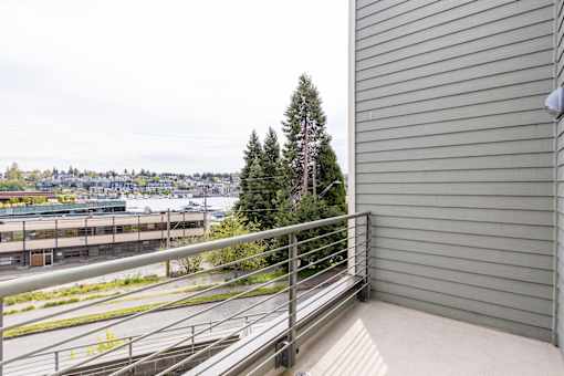 A balcony with a metal railing overlooks a cityscape.