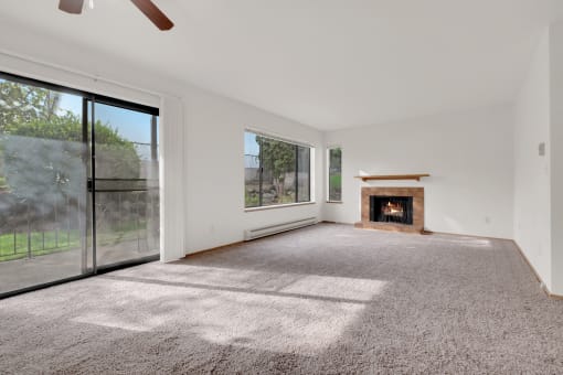 an empty living room with a fireplace and a large window