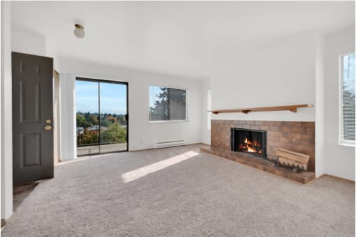a living room with a fireplace and a door to a balcony