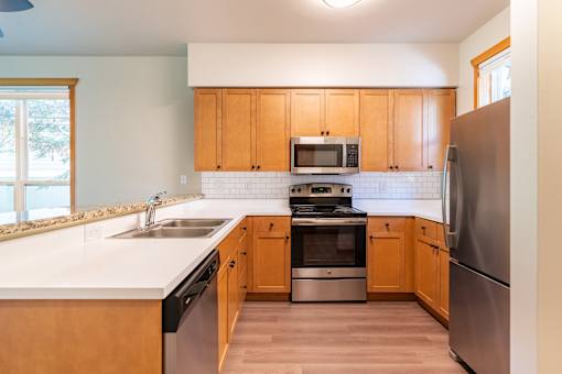 A kitchen with wooden cabinets and stainless steel appliances.