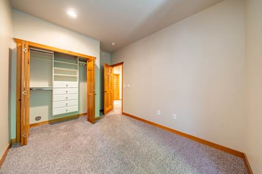 A room with a carpeted floor and a wooden door.