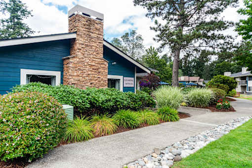 A blue house with a brick chimney and a stone pathway leading to the front door.