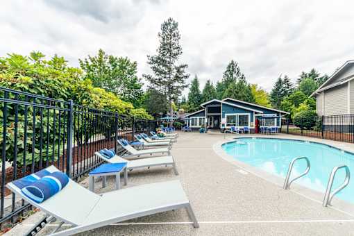 A pool area with sun loungers and a slide.