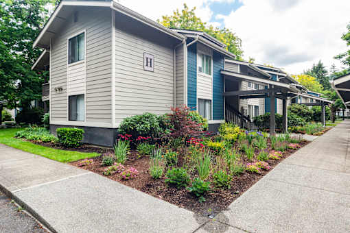 A row of houses with a sidewalk in front.