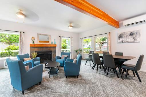 A living room with blue chairs and a fireplace.