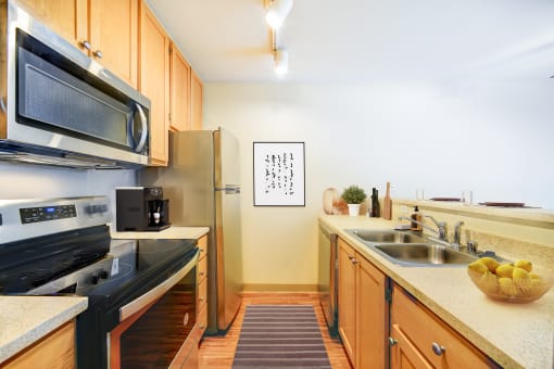 A kitchen with a black stove top oven and a black microwave above it.