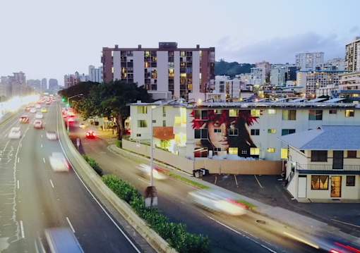A busy street with cars and buildings at dusk.