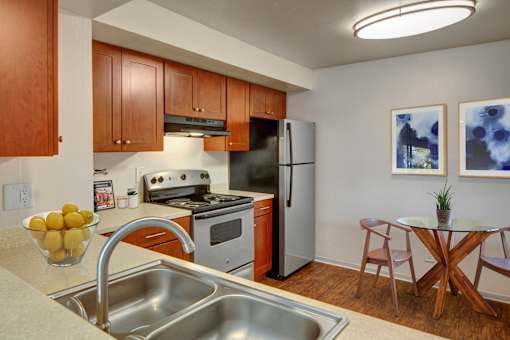 A kitchen with a stove, oven, refrigerator, and sink.