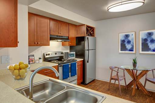 A kitchen with a stove, oven, refrigerator, and sink.