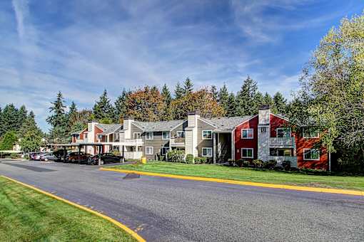 A street view of a residential area with houses and trees.