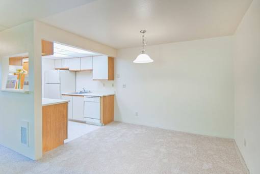 A kitchen with white cabinets and a white dishwasher.