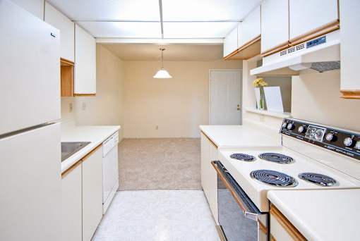 A kitchen with white appliances and cabinets.