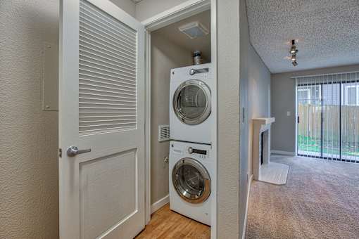 A white door opens to a laundry room with a washer and dryer.