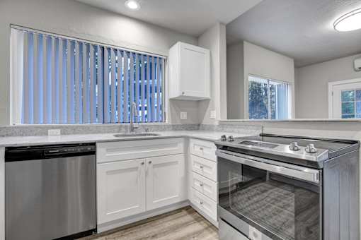 A modern kitchen with a dishwasher, sink, and oven.