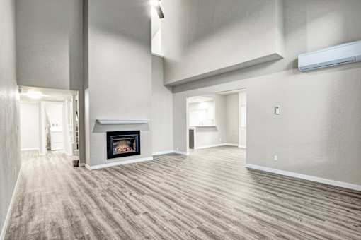 A spacious living room with a fireplace and hardwood floors.